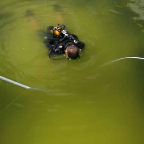 Technicien en plongée réalisant une détection de fuite