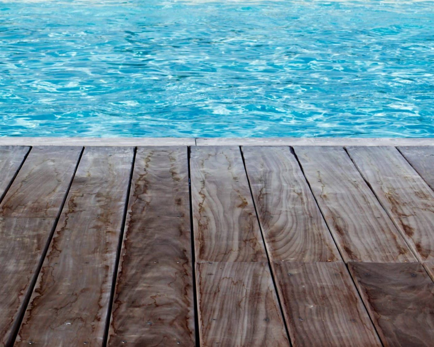 Illustration d'une piscine avec liner bleu et terrasse en bois exotique pour les services ASD Canalisation
